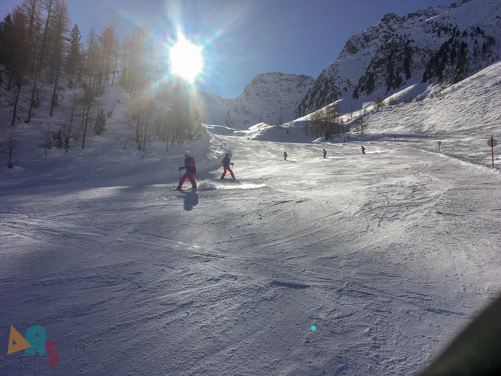 Piste im Gegenlicht mit einzelnen Fahrenden.